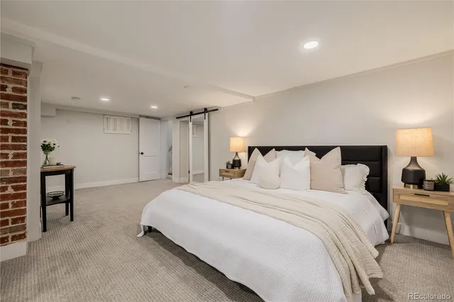 a spacious bedroom with a bed and a lamp