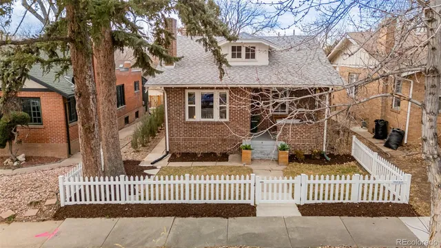 a view of a house with a small yard and wooden fence
