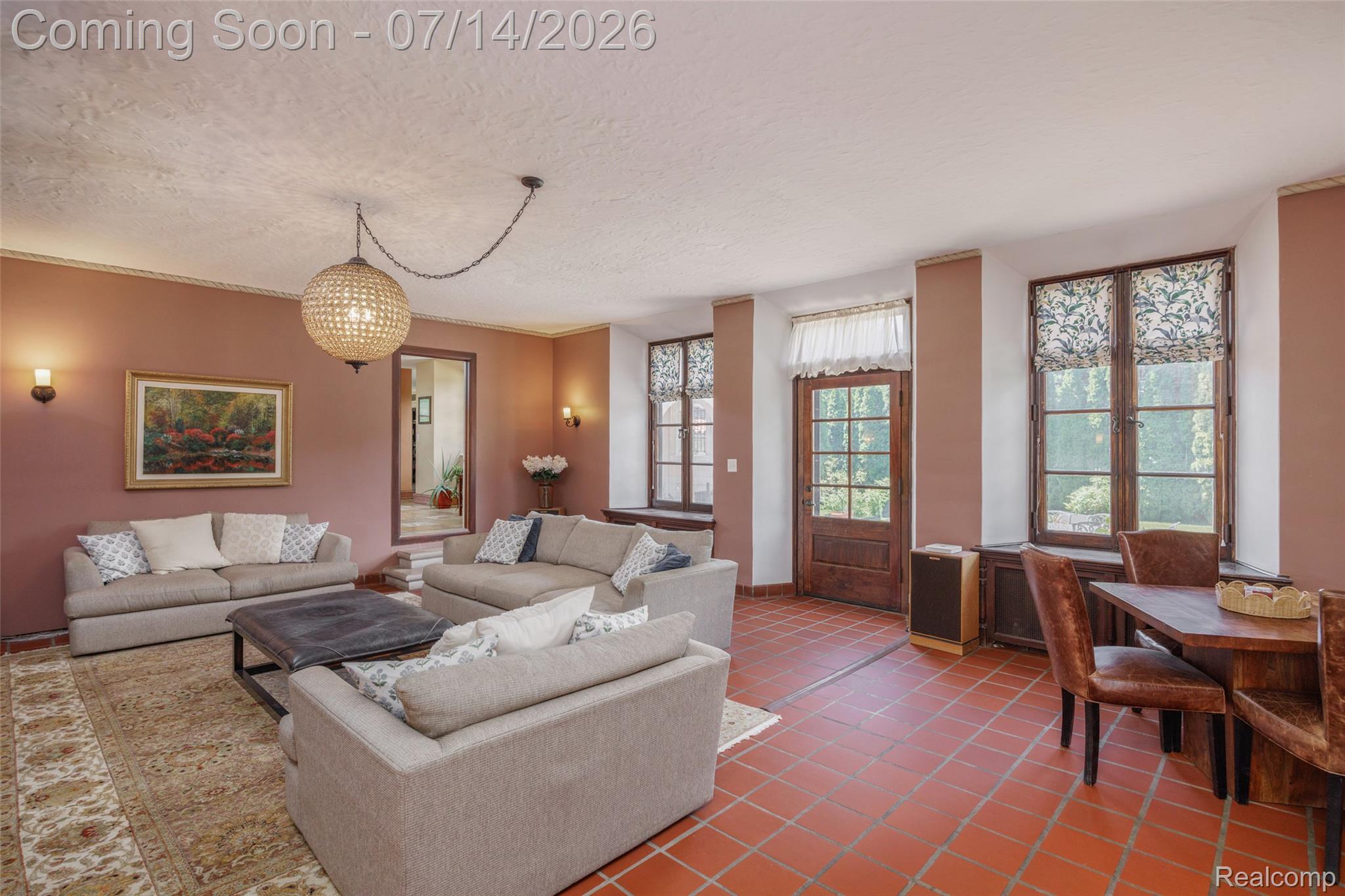 189 Cloverly Road Grosse Pointe, MI 48236 - Photo 19 of 96 Spacious living area featuring red-toned flooring, textured ceiling, a decorative chandelier, and multiple window openings