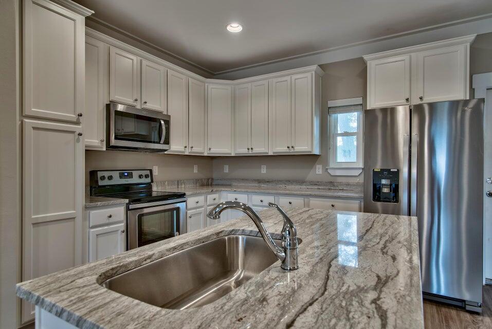 45 North Sand Palm Road Freeport, FL 32439 - Photo 6 of 32 a kitchen with granite countertop a sink a refrigerator and cabinets