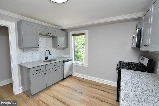 a kitchen with white cabinets a sink and dishwasher