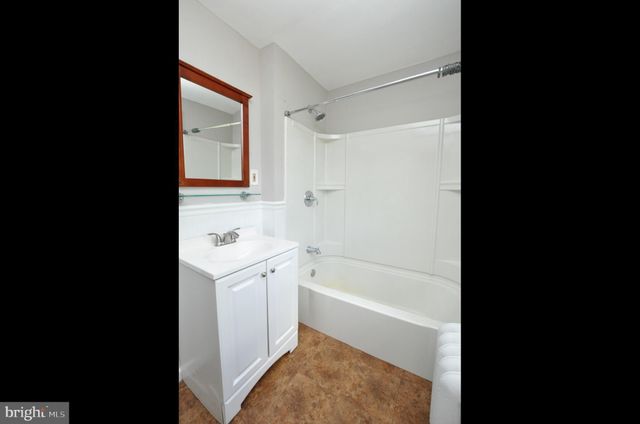 a bathroom with a tub sink and mirror
