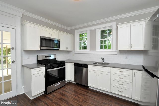 a kitchen with appliances a sink and a window