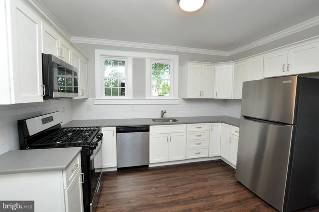 a kitchen with a refrigerator stove and wooden cabinets