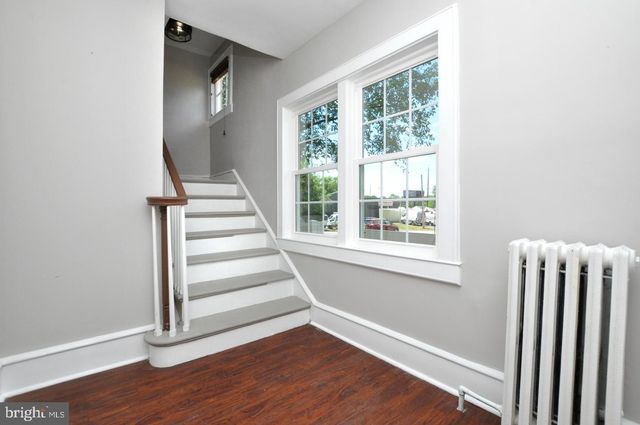 a view of an entryway with wooden floor and door
