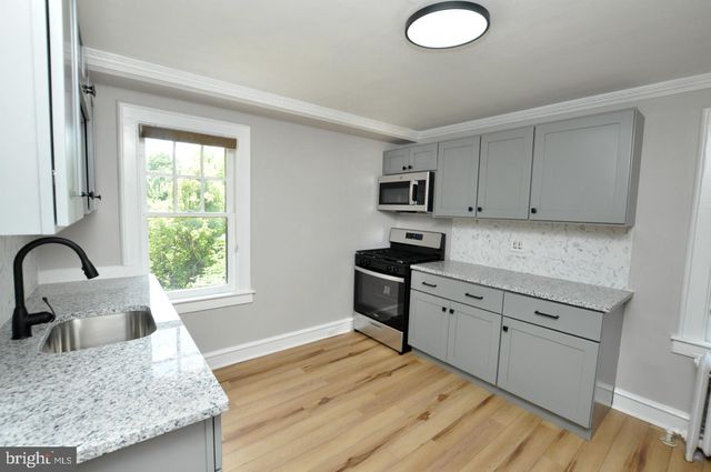a kitchen with granite countertop white cabinets and black appliances