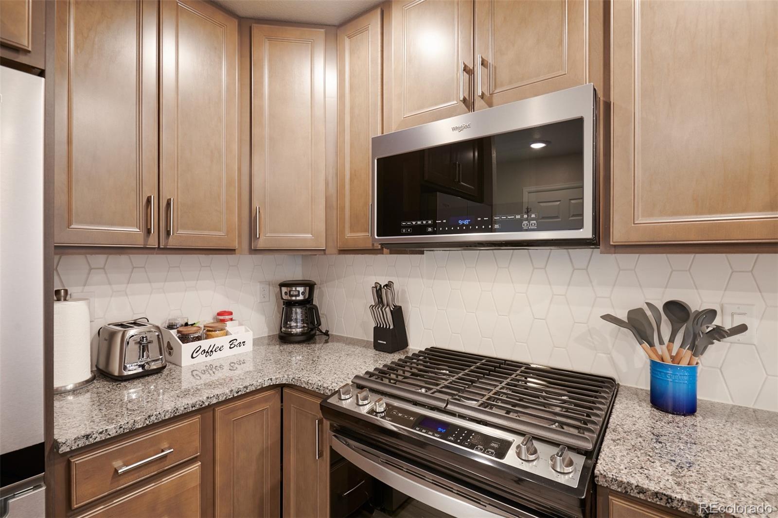 6339 North Hanover Street Denver, CO 80238 - Photo 8 of 24 a kitchen with stainless steel appliances granite countertop a stove a microwave and cabinets