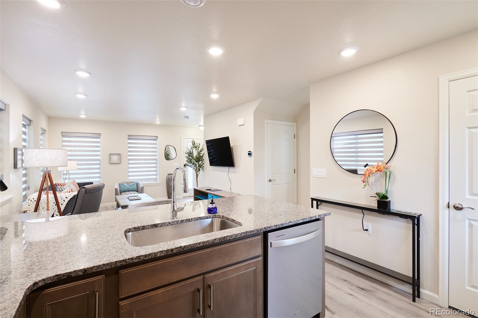 6339 North Hanover Street Denver, CO 80238 - Photo 9 of 24 a kitchen with a sink dishwasher a dining table and chairs with wooden floor