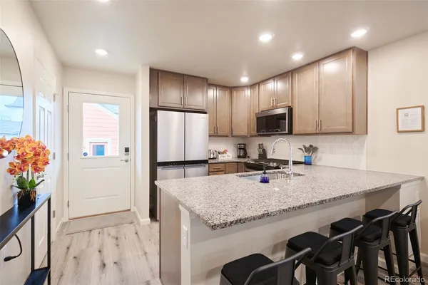 a kitchen with granite countertop a sink and a refrigerator