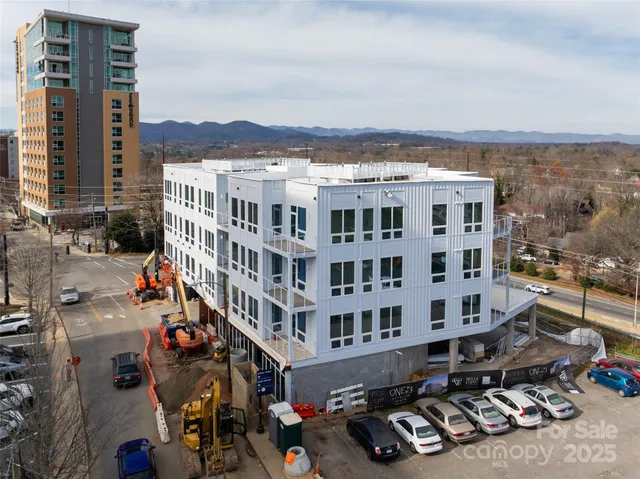 a front view of a building with streets and trees