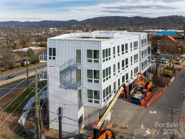 a view of a building with lot of cars parked on road