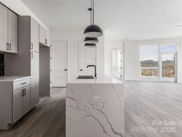 a kitchen with granite countertop a stove a sink and a refrigerator