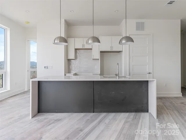 a kitchen with cabinets and wooden floor