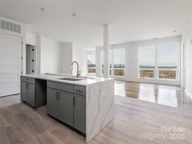 a kitchen with kitchen island granite countertop a stove top oven and sink