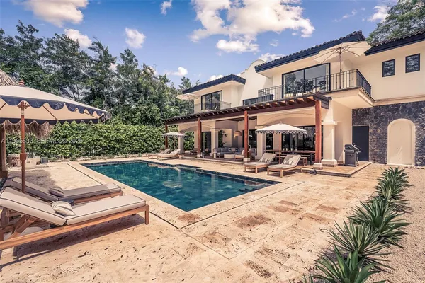 a view of a house with swimming pool and sitting area