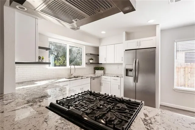 a kitchen with a stove a refrigerator and a window