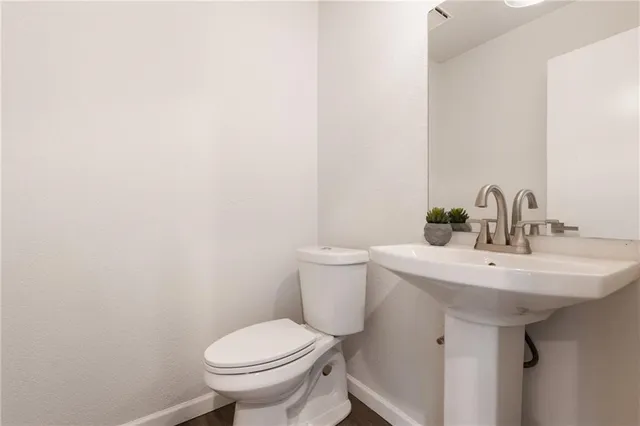 a bathroom with a sink a toilet and mirror