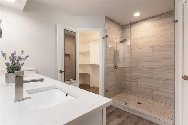 a bathroom with a shower sink and mirror