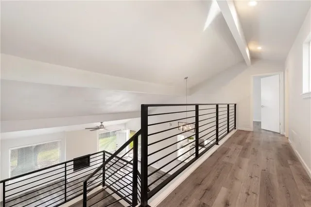 a view of a hallway with wooden floor and staircase