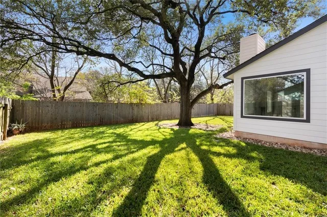 a view of house with backyard and tree