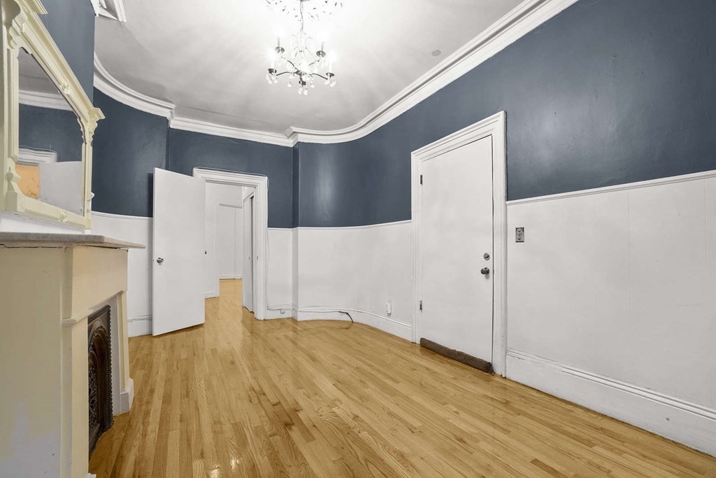 6 Dwight Street, Unit 1 Boston, MA 02118 - Photo 3 of 20 a view of empty room with wooden floor and fireplace