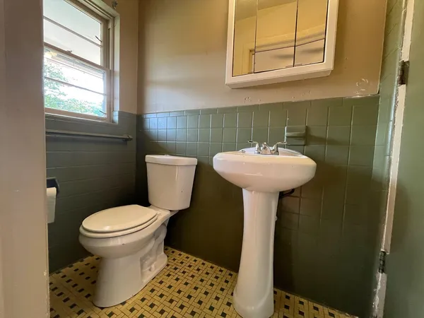 a bathroom with a sink toilet and a mirror
