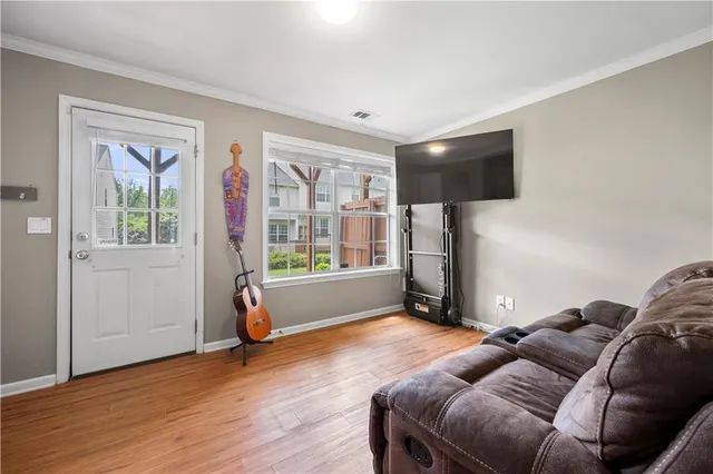 a living room with furniture a flat screen tv and a window