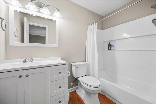 a bathroom with a toilet a sink a mirror a bathtub and vanity