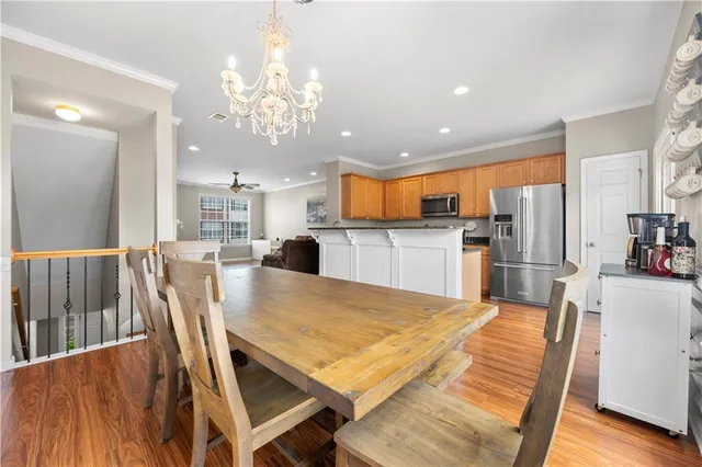 a kitchen with stainless steel appliances refrigerator dining table and chairs