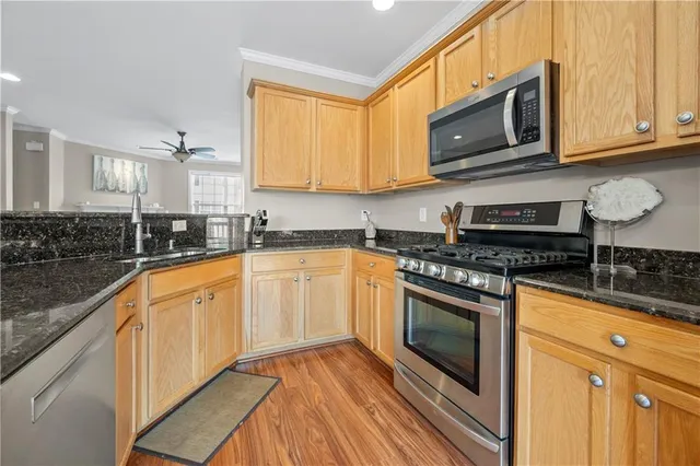 a large kitchen with stainless steel appliances granite countertop a stove a sink and a microwave