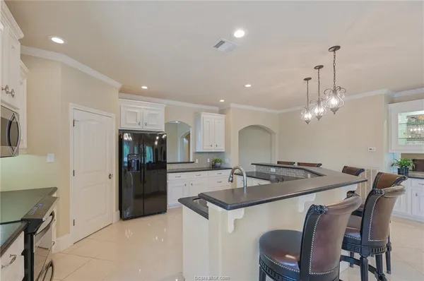 a kitchen with a dining table chairs refrigerator and stove