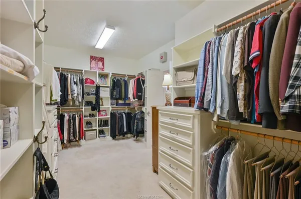 a view of walk in closet with clothes