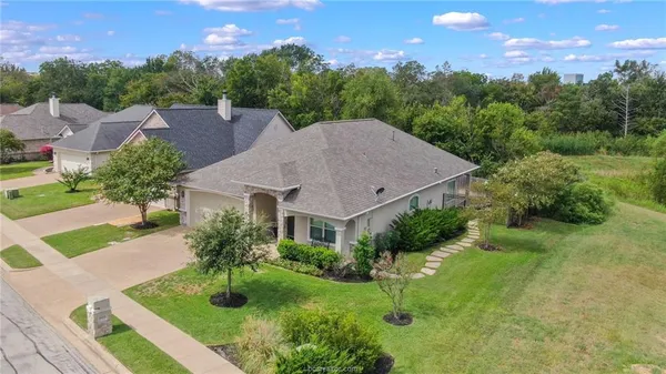 a aerial view of a house with yard and green space