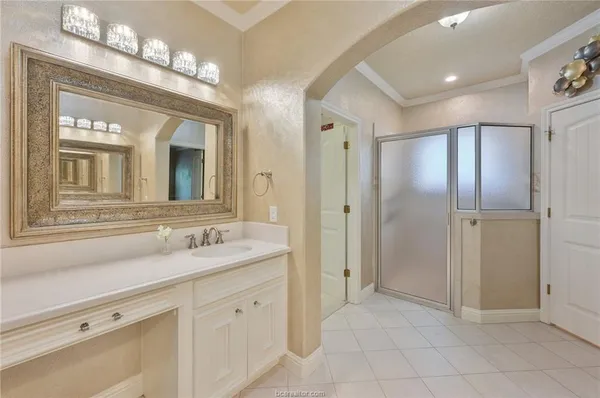 a spacious bathroom with a shower a sink and a mirror