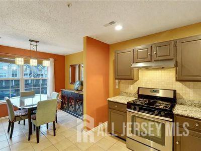 31 Edinburgh Court Edison, NJ 08820 - Photo 8 of 25 a kitchen with stainless steel appliances granite countertop a stove a sink and a microwave