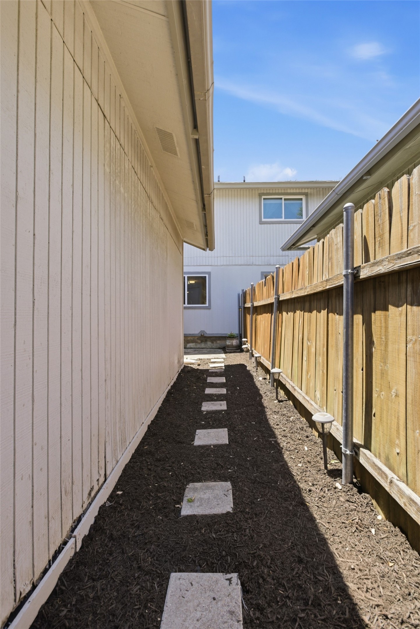 4204 Hudson Bend Road, Unit B Austin, TX 78734 - Photo 32 of 37 Side yard featuring a stepping stone pathway, dark ground cover, and a wooden fence
