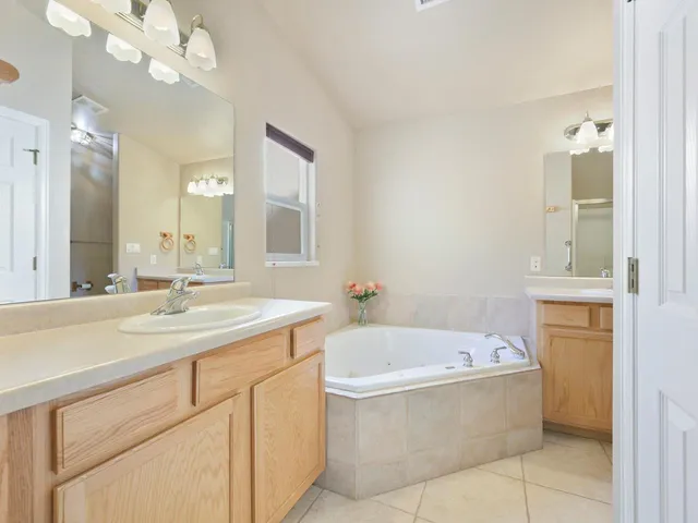 a bathroom with a tub a sink and a mirror