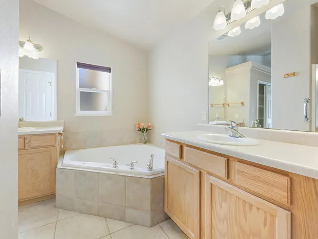 a bathroom with a tub a sink and a mirror