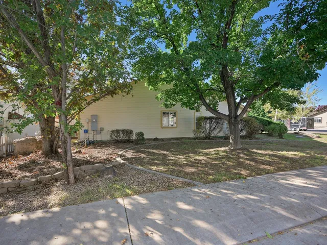 a backyard of a house with barbeque oven table and chairs