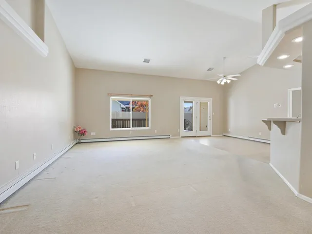 an empty room with a windows and ceiling fan