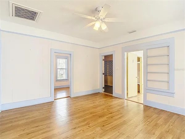 a view of a livingroom with wooden floor and a kitchen space with wooden floor