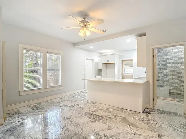 a kitchen with stainless steel appliances granite countertop a sink a stove a refrigerator and white cabinets