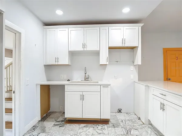 a kitchen with granite countertop a sink appliances cabinets and a large window