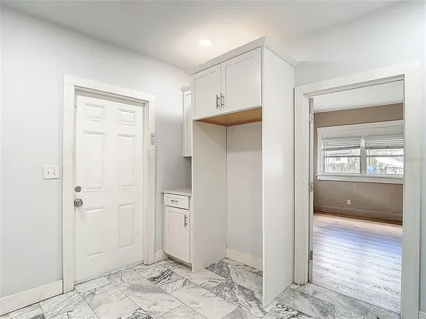 a kitchen with white cabinets and wooden floor