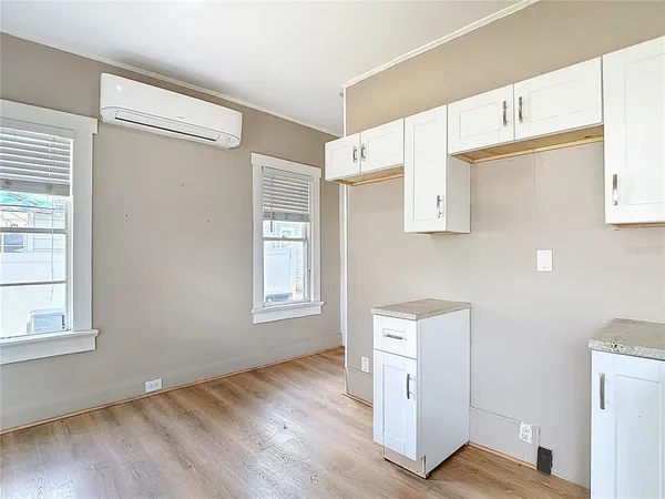 a view of an empty room with a window and wooden floor