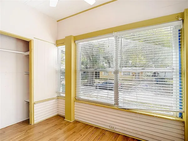 a view of empty room with wooden floor and fan