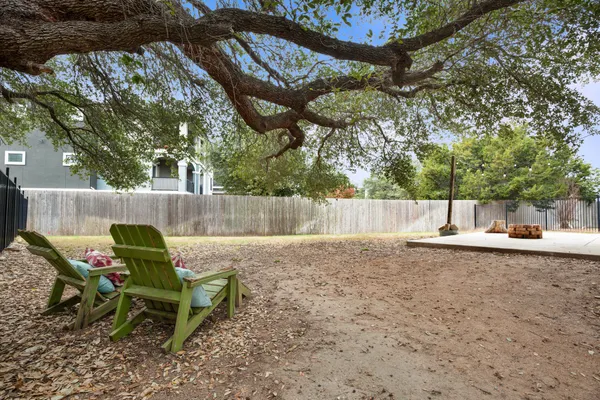 a view of a yard with a slide and a tree