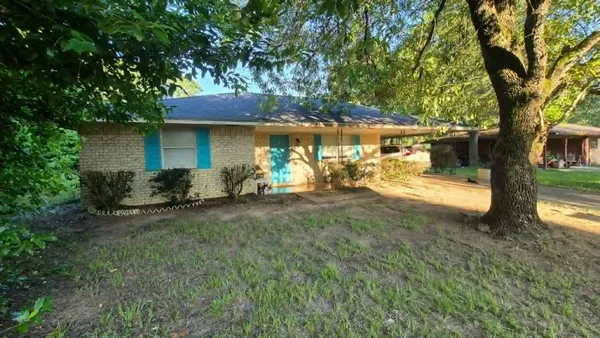 a view of a house with backyard and a tree