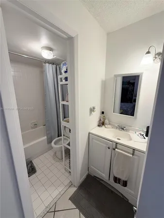 a bathroom with a sink a toilet a mirror and shower