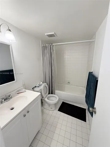 a bathroom with a toilet a sink a mirror and a bathtub